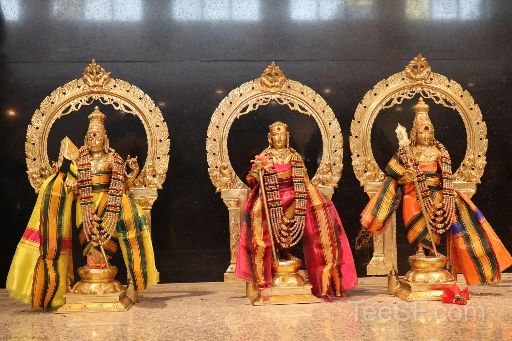 A golden shrine with colorful deity figures inside Shiva Murugan Temple.